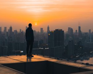 Preview wallpaper roof, man, city, sunset, buildings, overview