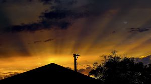 Preview wallpaper roof, pillar, silhouettes, sunset, dark, rays