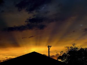 Preview wallpaper roof, pillar, silhouettes, sunset, dark, rays