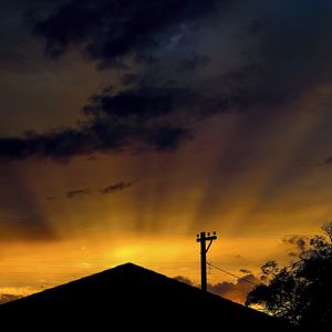 Preview wallpaper roof, pillar, silhouettes, sunset, dark, rays