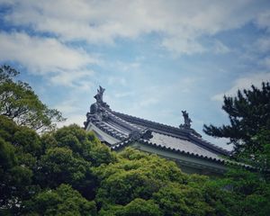 Preview wallpaper roof, trees, sky, clouds