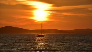 Preview wallpaper sailboat, boat, sea, sunset, glare