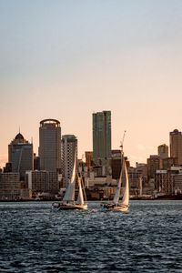 Preview wallpaper sailboat, city, buildings, skyscrapers, water