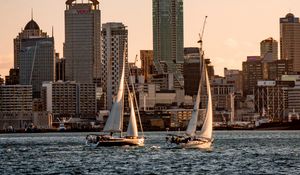 Preview wallpaper sailboat, city, buildings, skyscrapers, water