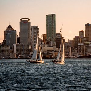 Preview wallpaper sailboat, city, buildings, skyscrapers, water