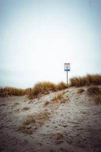 Preview wallpaper sand, grass, sign, hill