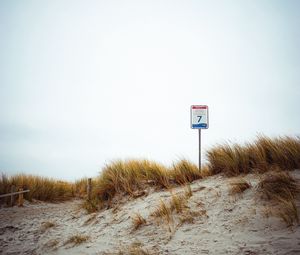 Preview wallpaper sand, grass, sign, hill