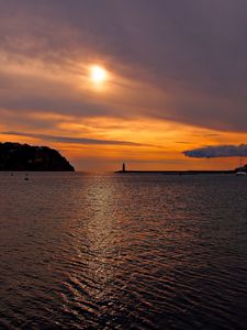 Preview wallpaper sea, bay, lighthouse, mountains, sunset, clouds, sun