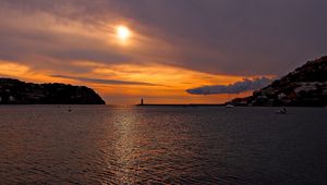 Preview wallpaper sea, bay, lighthouse, mountains, sunset, clouds, sun