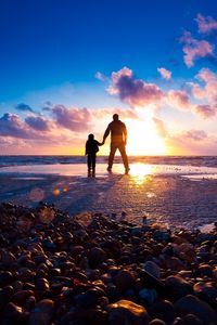 Preview wallpaper sea, beach, rocks, sunset, sun, rays, light