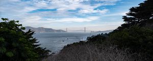 Preview wallpaper sea, bridge, mountains, trees, branches, view