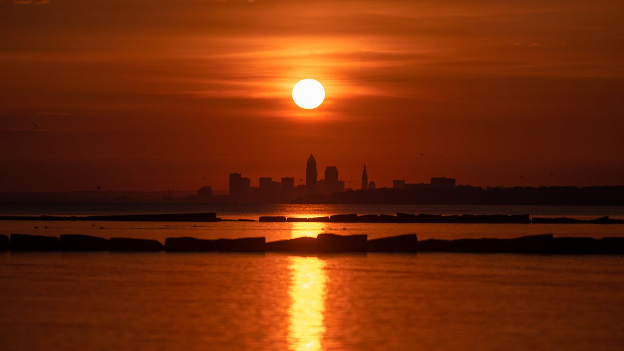 Wallpaper sea, city, skyscrapers, sunset, rays, dark