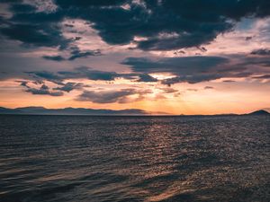 Preview wallpaper sea, clouds, sunlight, ripples, shore, mountains