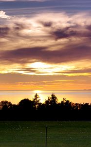 Preview wallpaper sea, clouds, trees, field, evening