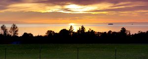 Preview wallpaper sea, clouds, trees, field, evening