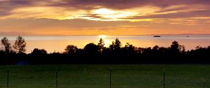 Preview wallpaper sea, clouds, trees, field, evening