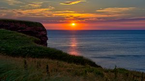 Preview wallpaper sea, coast, grass, sunset