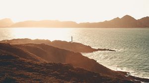 Preview wallpaper sea, coast, hills, lighthouse, sunlight