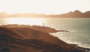 Preview wallpaper sea, coast, hills, lighthouse, sunlight