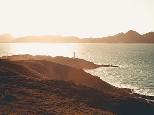 Preview wallpaper sea, coast, hills, lighthouse, sunlight