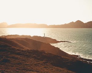 Preview wallpaper sea, coast, hills, lighthouse, sunlight