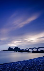 Preview wallpaper sea, coast, stones, bridge, sunset, evening