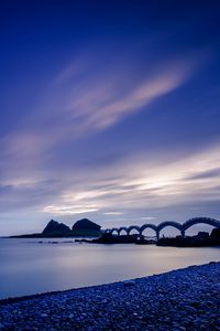 Preview wallpaper sea, coast, stones, bridge, sunset, evening