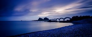 Preview wallpaper sea, coast, stones, bridge, sunset, evening