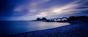 Preview wallpaper sea, coast, stones, bridge, sunset, evening