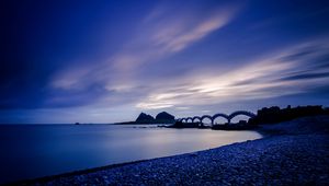 Preview wallpaper sea, coast, stones, bridge, sunset, evening