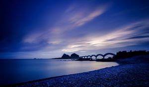 Preview wallpaper sea, coast, stones, bridge, sunset, evening