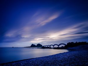 Preview wallpaper sea, coast, stones, bridge, sunset, evening