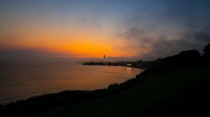 Preview wallpaper sea, coast, tower, clouds, evening, sky