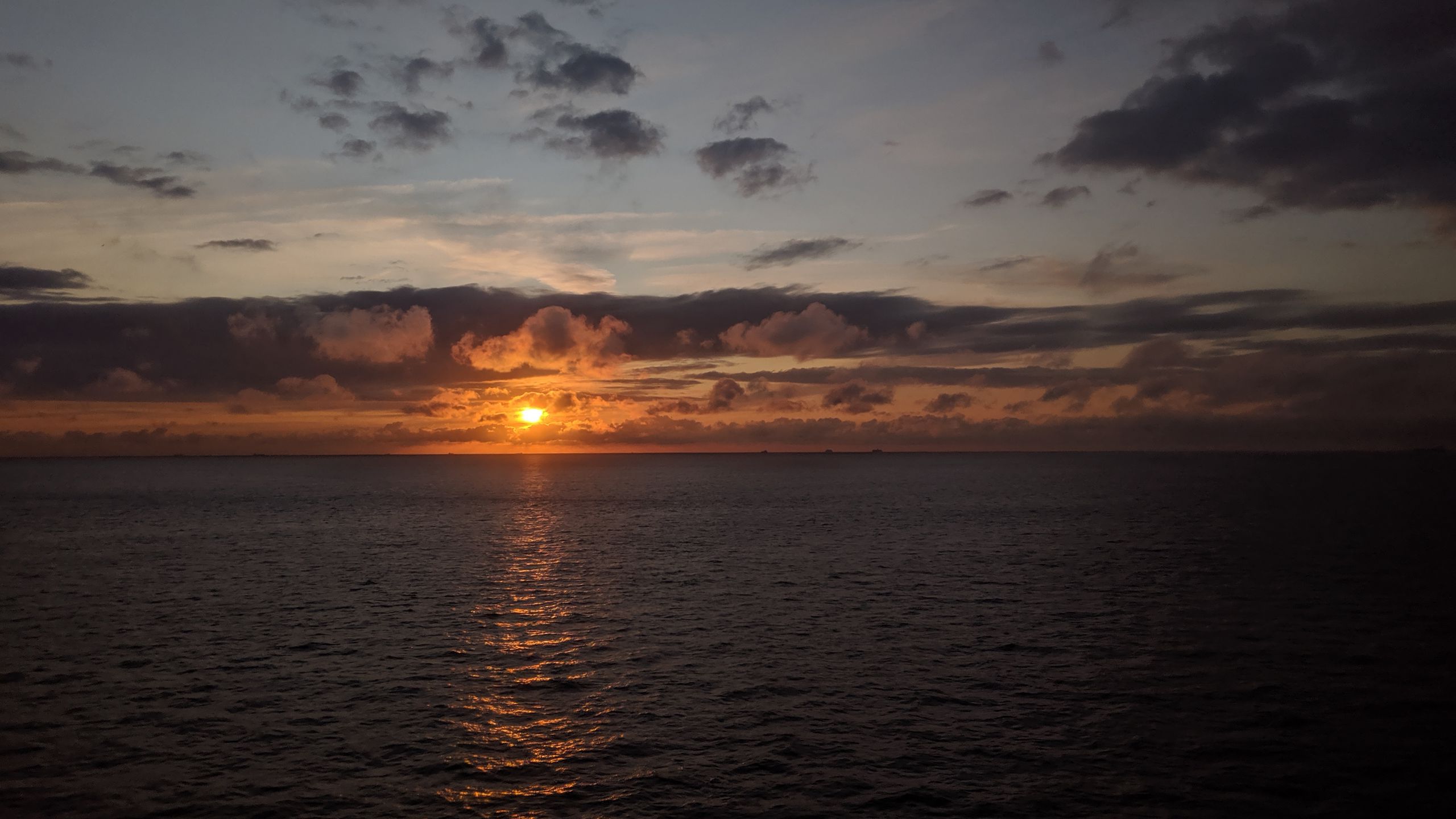 Download wallpaper 2560x1440 sea, horizon, clouds, sun, sunset, dark