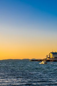 Preview wallpaper sea, houses, sky, sunset