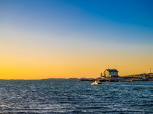 Preview wallpaper sea, houses, sky, sunset