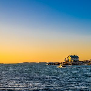Preview wallpaper sea, houses, sky, sunset