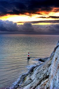 Preview wallpaper sea, lighthouse, rock, sunset