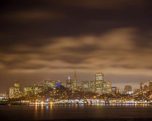 Preview wallpaper sea, lights, skyscrapers, clouds, sky, city