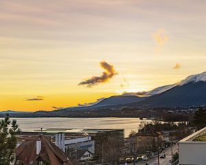 Preview wallpaper sea, mountains, buildings, sky, evening