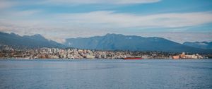 Preview wallpaper sea, mountains, buildings, city, clouds