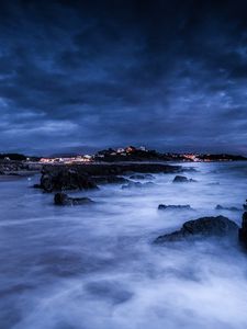 Preview wallpaper sea, night, moon, clouds, rocks, shore, lights