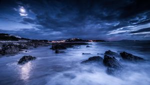 Preview wallpaper sea, night, moon, clouds, rocks, shore, lights