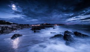 Preview wallpaper sea, night, moon, clouds, rocks, shore, lights