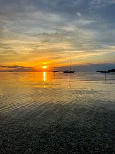 Preview wallpaper sea, pebbles, bottom, boats, sunset