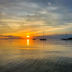 Preview wallpaper sea, pebbles, bottom, boats, sunset