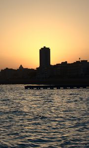 Preview wallpaper sea, pier, buildings, city, silhouettes, evening