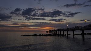 Preview wallpaper sea, pier, lights, clouds, sunset