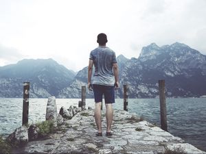 Preview wallpaper sea, pier, mountains, man, freedom