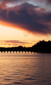 Preview wallpaper sea, pier, pilings, trees, evening, silhouettes